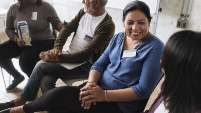 Four patients sitting in a cicle at a behavioral health facility meeting
